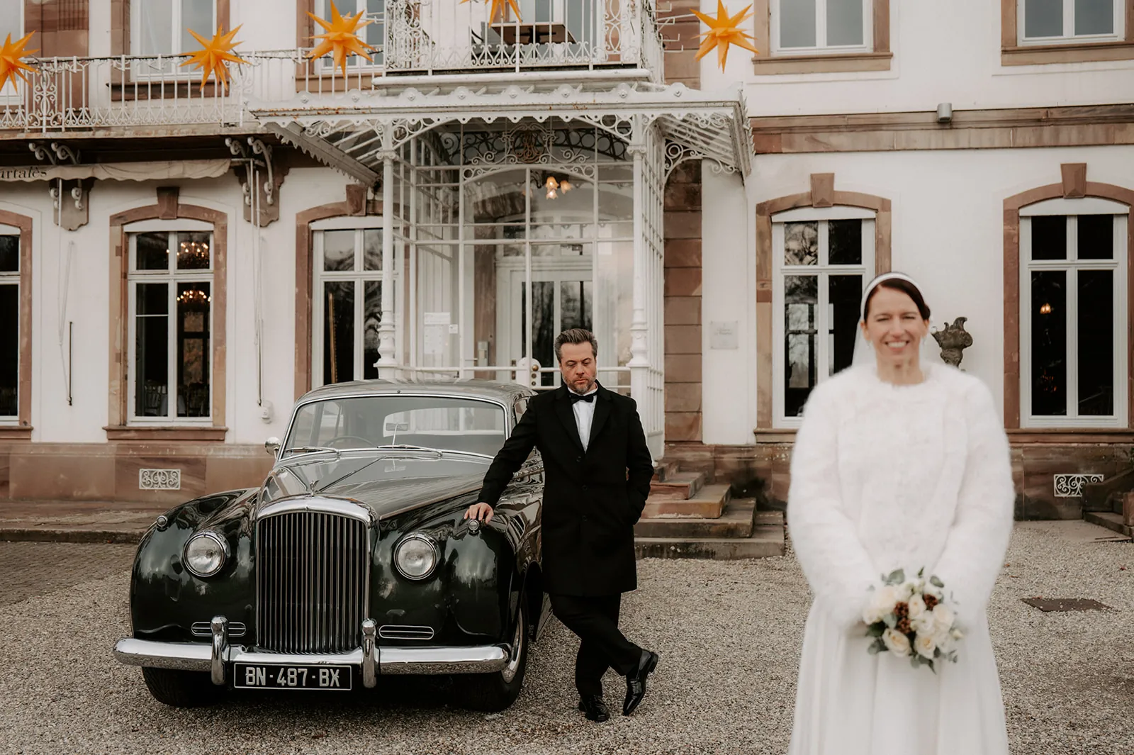 Newlyweds in front of Château de Pourtalès with a vintage Bentley