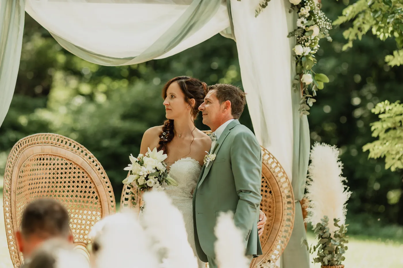 Outdoor ceremony under a draped arch at Domaine du Hirtz