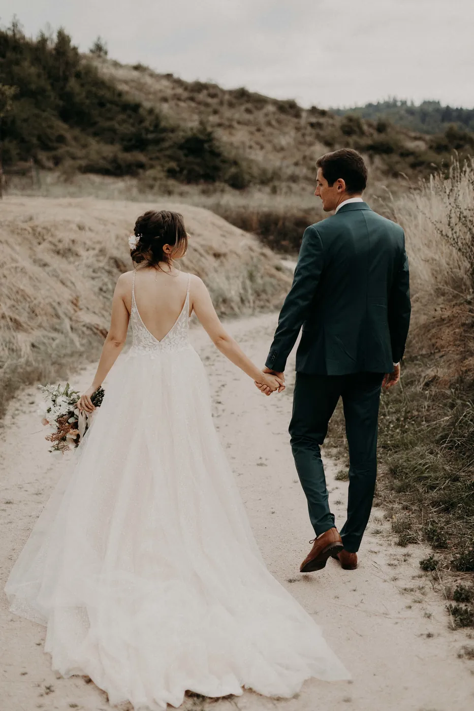 Newlyweds walking hand in hand on a country path, Ferme d'Argentin
